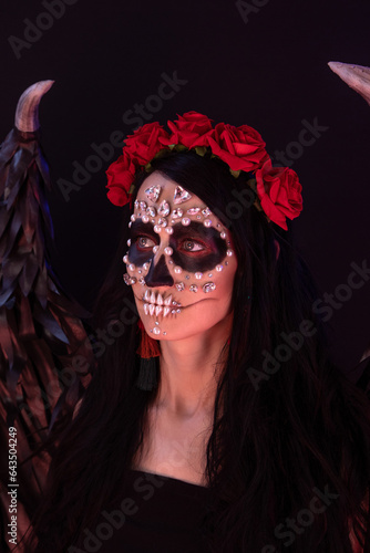 woman look as angel Death with red  roses wreath  closeup