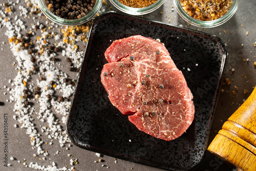 seasoned raw meat with salt and pepper for steak.	