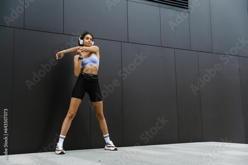 African woman doing stratching exercises during workout outdoors