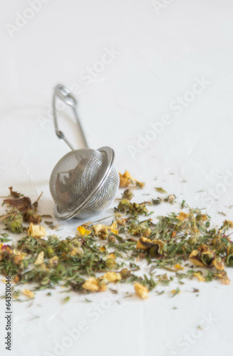 Fragrant natural tea in a strainer and scattered on the table.
