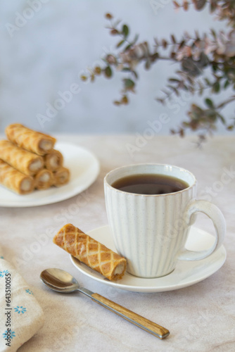 Coffee and dessert from waffle rolls with cream.