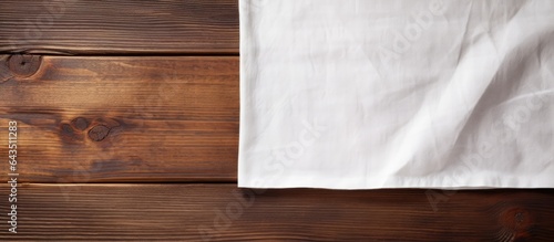 Napkin on right side of wooden table seen from above with room for text