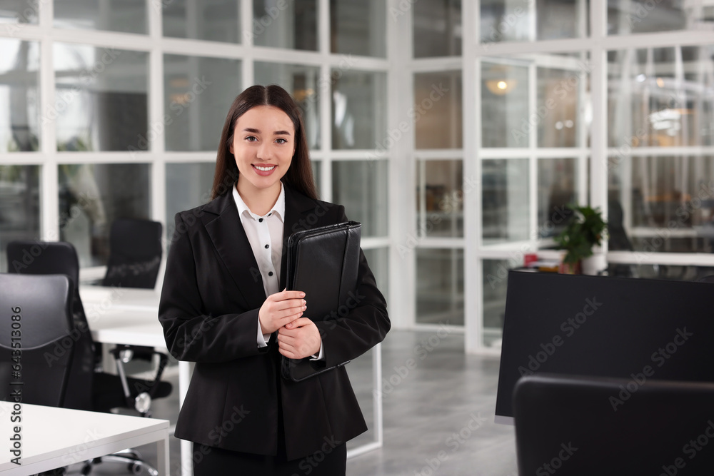 Happy real estate agent with leather portfolio in office Happy real estate agent with leather portfolio in office