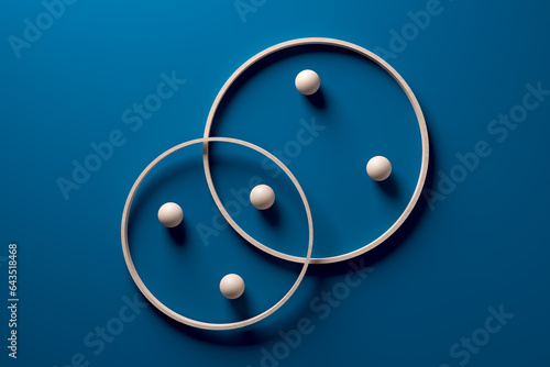 Фотография Crossing wooden rings with spheres on blue background.