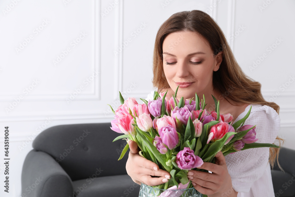Young woman with bouquet of beautiful tulips indoors Young woman with bouquet of beautiful tulips indoors