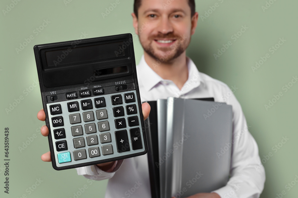 Happy accountant with calculator and folders on olive background, selective focus Happy accountant with calculator and folders on olive background, selective focus
