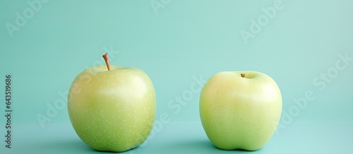 Minimal concept with copy space showcasing organic nutrition and a natural pattern consisting of two fresh apples against a pastel mint green backdrop