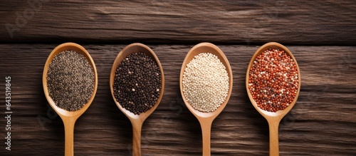 Top down view of white red and black quinoa seeds on wooden background with room for text