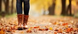 Copy space with autumn park s background depicts girl in leather shoes standing
