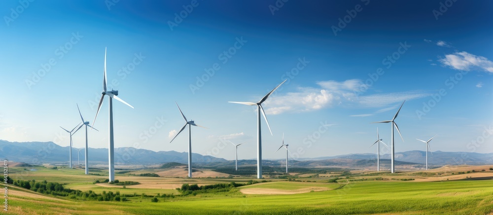 Panoramic view of wind farm with tall wind turbines generating ...