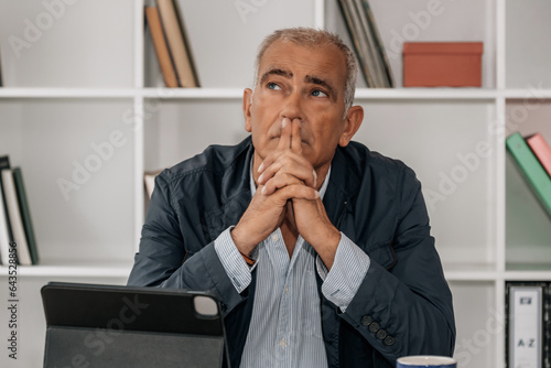 thoughtful middle aged business man in office