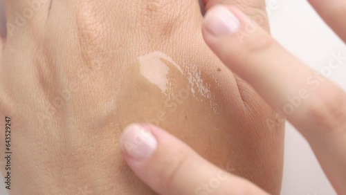 Female hands care. Close up of woman applying serum gel on hand skin. Serum oil with hyaluronic acid applied by a woman's hand, skin care cosmetics, moisturizing gel.