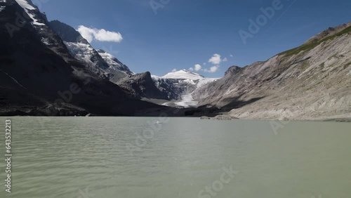 Alpine lake water surface from the fastest melting glacier Pasterze at the foot of the Grossglockner Mountain in the Austrian Alps photo