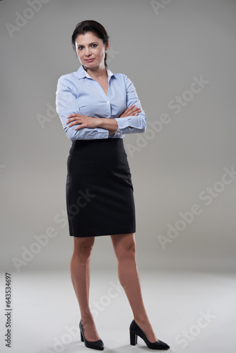 Brunette mature businesswoman on gray