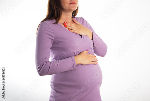 A pregnant girl who has heartburn in her stomach. Reflux of hydrochloric acid into the esophagus. Heartburn in pregnancy. photo