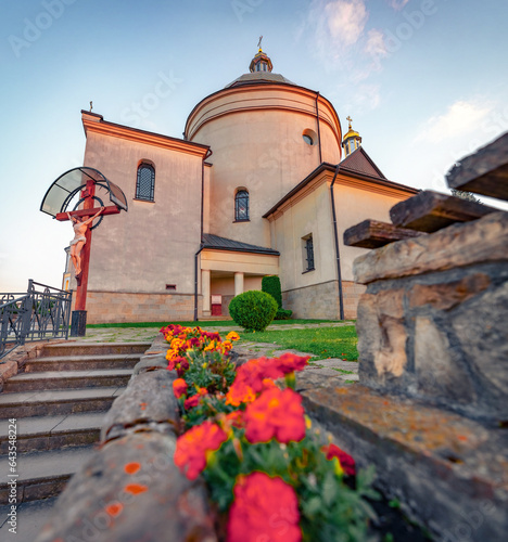 Blooming red flowers on the yard of Basilian Monastery of Jasna Gora. Splendid summer scene of Hoshiv countryside, Ivano-Frankivsk region, Ukraine, Europe. Traveling concept background.. photo