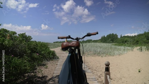 Bicycle by the sea on a sunny day among the sand. The girl left the bike on the shore and went to the sea. Seascape.