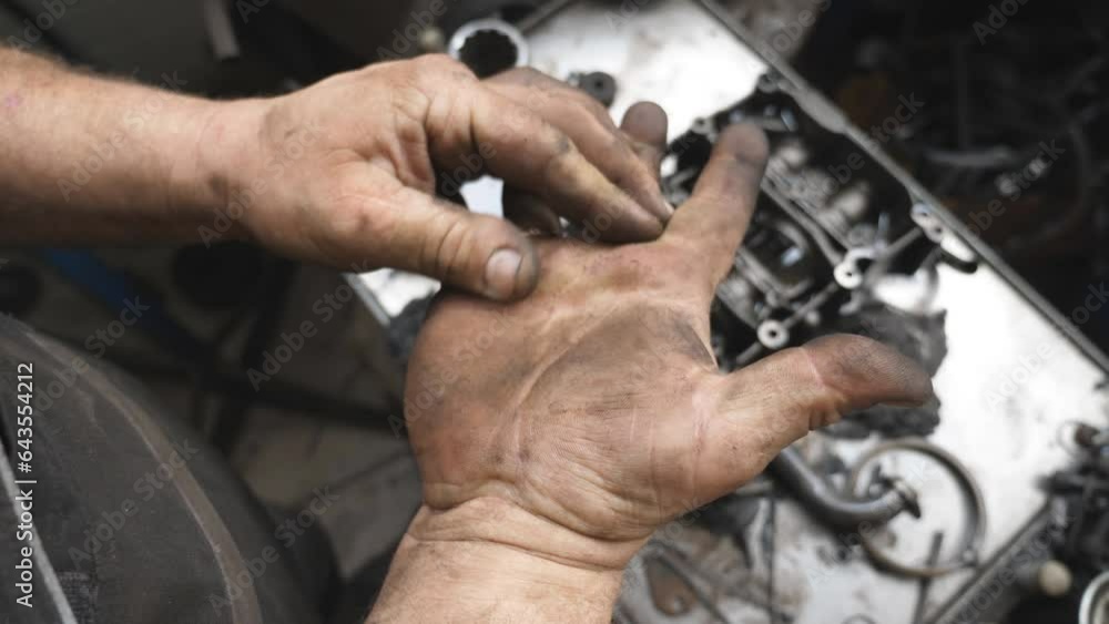 POV male dirty hands of young mechanic at workshop. Repairman rubbing unclean arms from fuel oil after hard work at garage. Concept of maintenance service. Slow motion