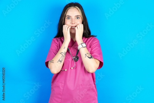 Fearful young beautiful doctor woman keeps hands near mouth, feels frightened and scared,  has a phobia,  Shock and frighted concept.