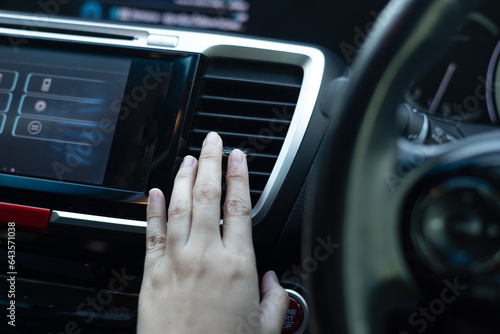 Close up woman hand is checking air conditioner in the car. Car cooling control button. hot air conditioner in car, heat and warm, checking air. over cooling or over heating in car.