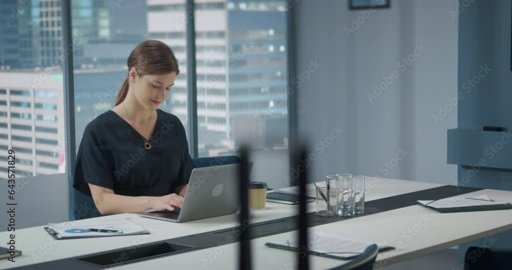 Portrait of Successful Caucasian Businesswoman Working on Laptop Computer in Her Big City Corner Office. Professional Female Digital Entrepreneur does Data Analysis for e-Commerce. Portrait of Successful Caucasian Businesswoman Working on Laptop Computer in Her Big City Corner Office. Professional Female Digital Entrepreneur does Data Analysis for e-Commerce.