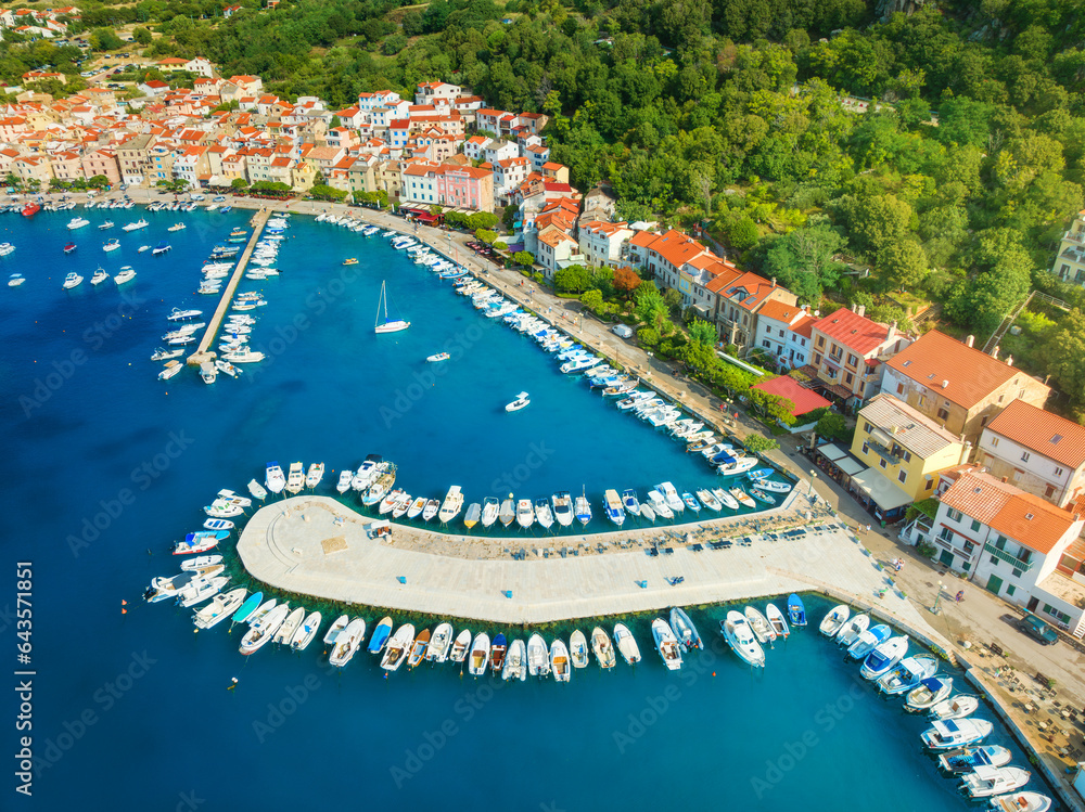 Aerial view of boats and luxury yachts, buildings at summer sunrise. Beautiful city Baska, Krk island, Croatia. Colorful landscape with sailboats and motorboats, architecture, sea bay, jetty. Top view