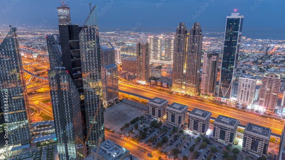 Obraz premium High-rise buildings on Sheikh Zayed Road in Dubai aerial night to day timelapse, UAE.