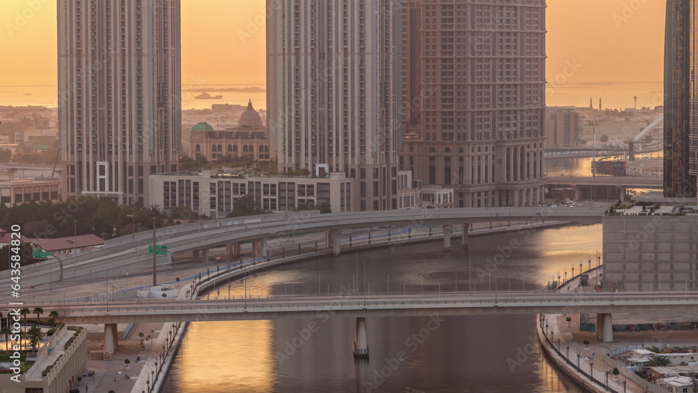 Fototapeta premium Walking promenade along water canal in Business Bay district of Dubai aerial timelapse.