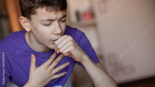 A teenage boy uses an allergy and asthma inhaler