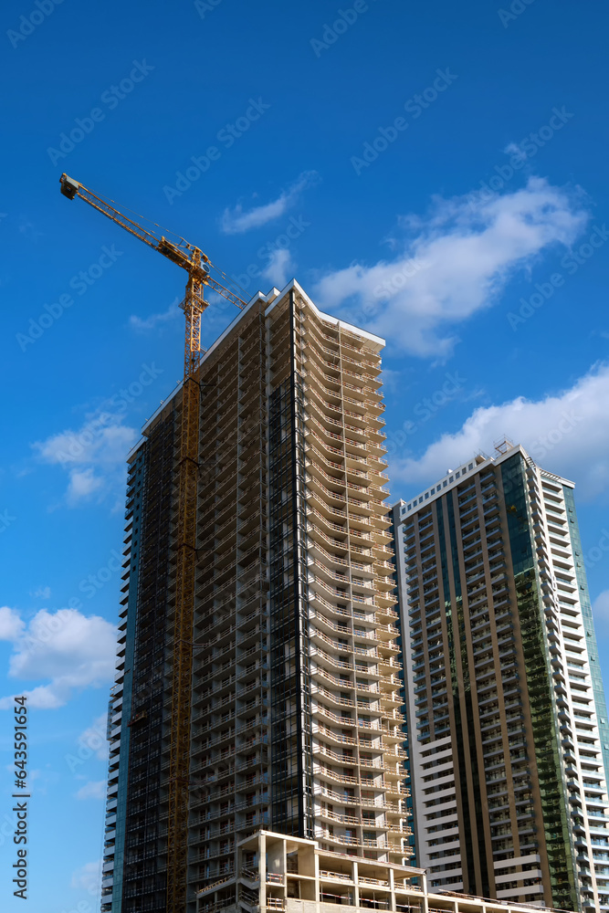 Fototapeta premium Vertical image of the construction of a new residential skyscraper