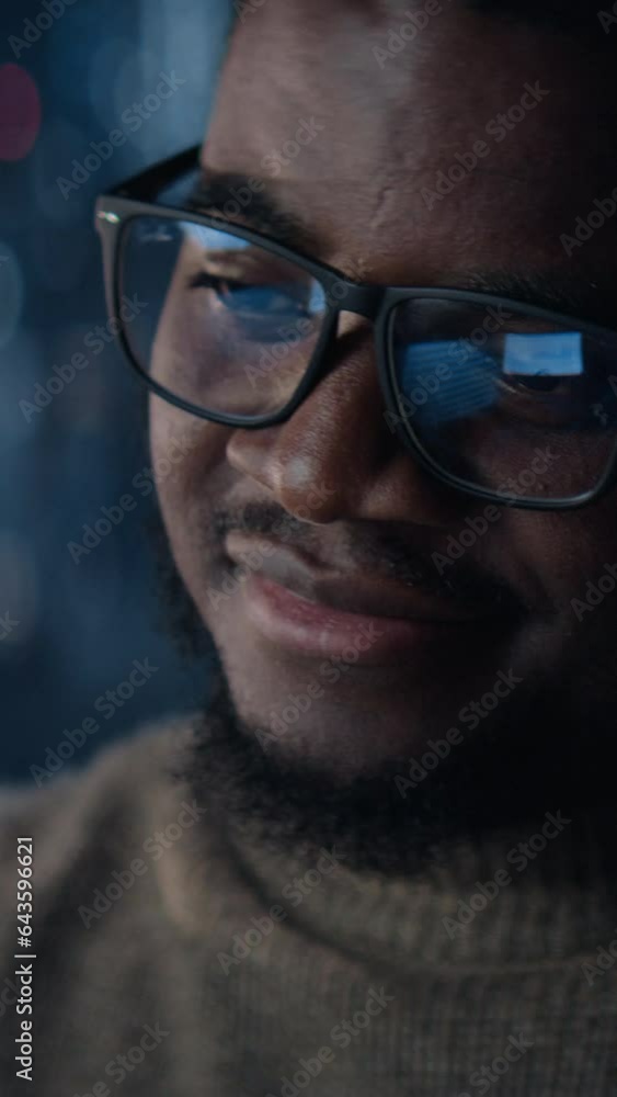 Vertical Screen: Close Up Portrait Of Successful Handsome Black Businessman Working on Laptop Late Night in Big City Office. Investment Manager Checking Financial Data from Project Management Report. Vertical Screen: Close Up Portrait Of Successful Handsome Black Businessman Working on Laptop Late Night in Big City Office. Investment Manager Checking Financial Data from Project Management Report.