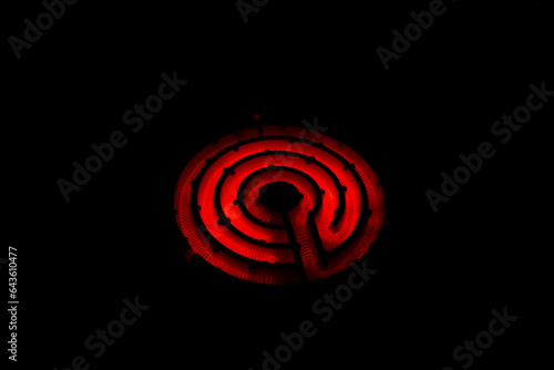 真っ赤に加熱したコイル状の電熱線（ニクロム線）黒背景にレトロな電気コンロの写真