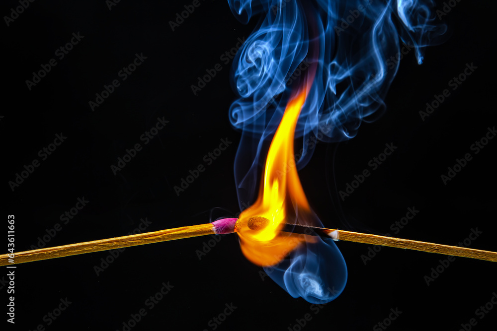 Fire and smoke. Burning and smoking match on a black background. Heat and light from fire flame Fire and smoke. Burning and smoking match on a black background. Heat and light from fire flame