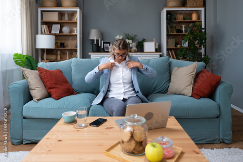 Cuadro en lienzo Young businesswoman sitting at home preparing for an unplanned video call with clients putting on a formal wear while down in a tracksuit
