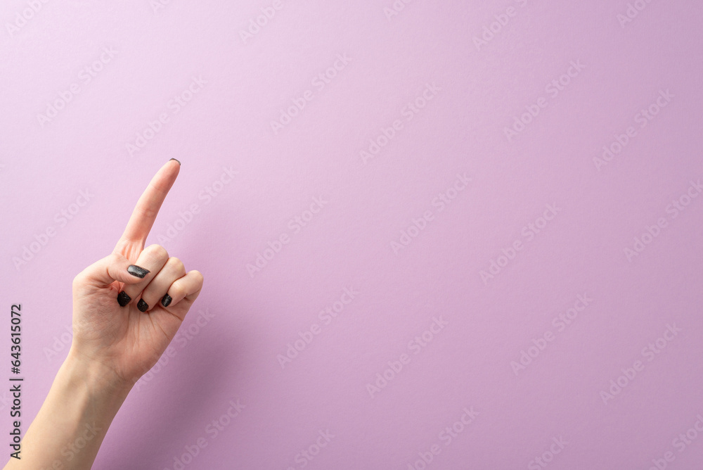 From first person top view, the hand of a young lady, complete with stylish black manicure, creates a pointed gesture using her index finger. The lilac background provides text or ad placement - obrazy, fototapety, plakaty 