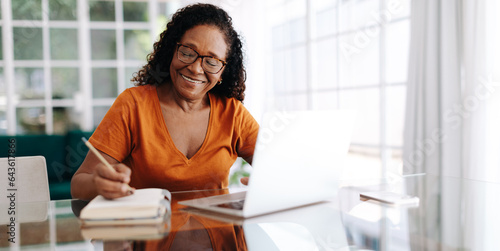 Vászonkép Happy senior woman drafting her last will and testament in her journal