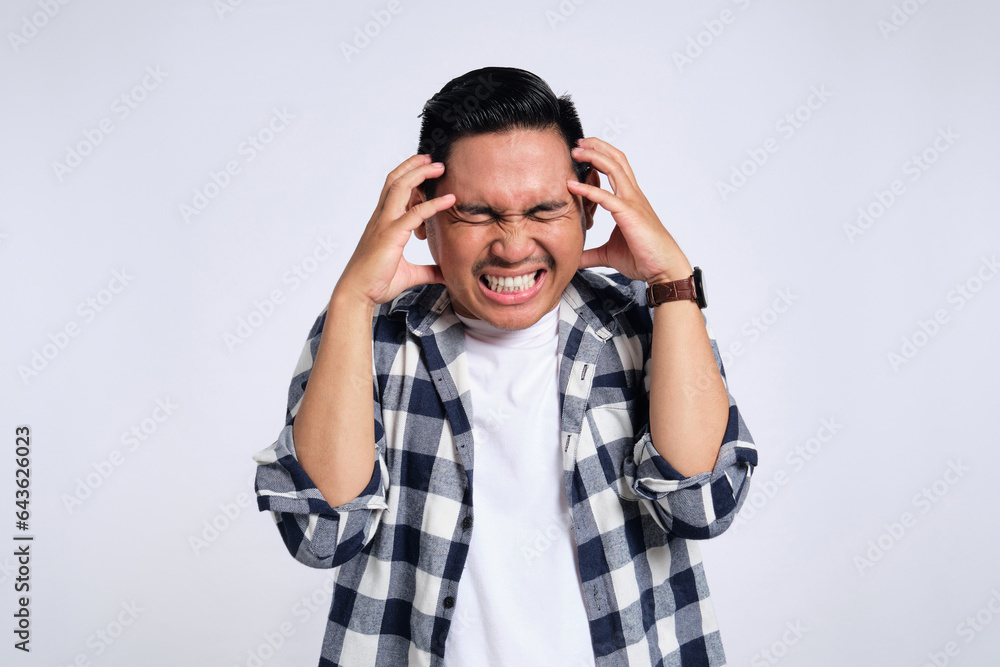 Portrait of annoyed young Asian man in casual shirt raising his hand, screaming with angry facial expression isolated on white background Portrait of annoyed young Asian man in casual shirt raising his hand, screaming with angry facial expression isolated on white background