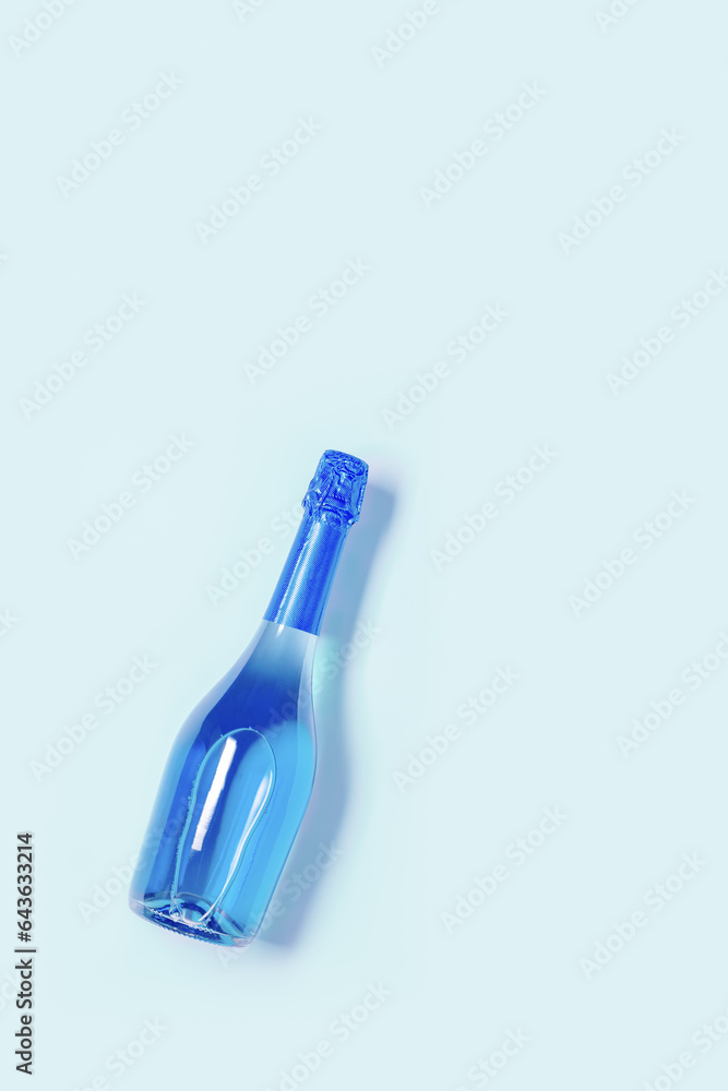 Minimal style Top view sparkling wine sky blue color, bottle of champagne on blue background, copy space. Summer Festive alcohol drink, wedding party drink concept, cyan pastel wine card Minimal style Top view sparkling wine sky blue color, bottle of champagne on blue background, copy space. Summer Festive alcohol drink, wedding party drink concept, cyan pastel wine card
