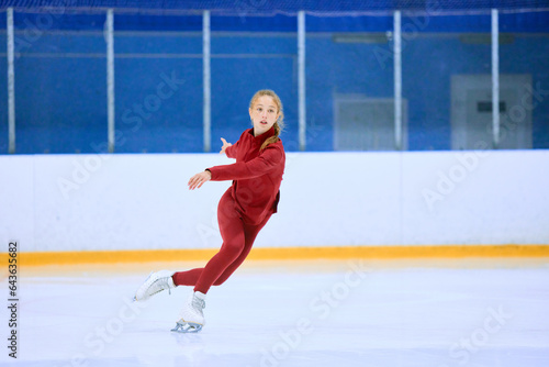 Photos Concentrated and motivated teen girl in red sportswear training, skating on ice rink arena