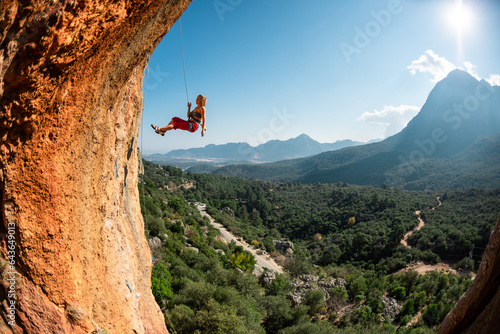 Rock climber descends from the route, the climber hangs on a rope, a rock in the form of an arch, climbing routes in a cave