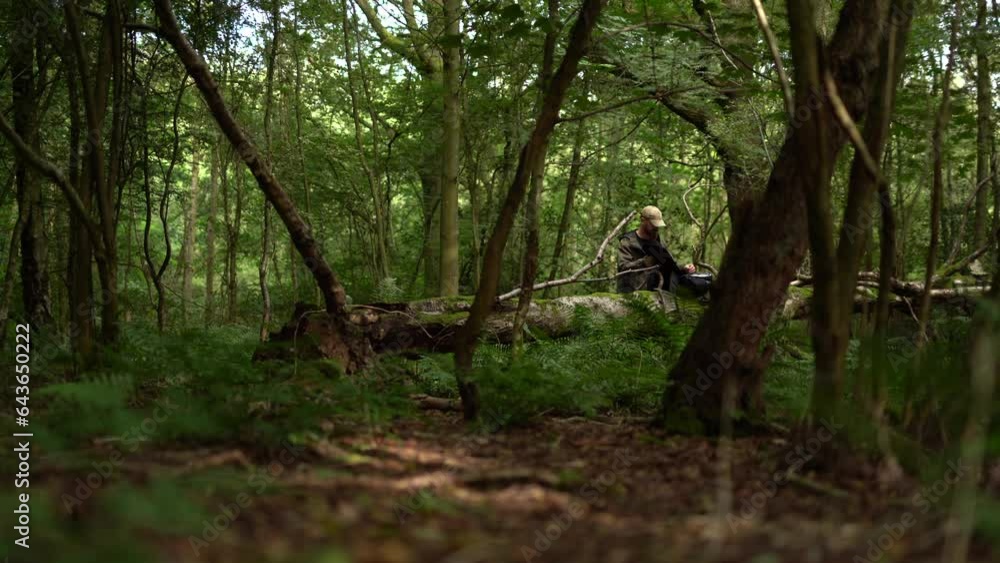 A man in a woodland, packing a bag and leaving A man in a woodland, packing a bag and leaving