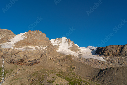 Gran Paradiso mountain and glacier view from chabod hut at sunset. golden hour, colored peak against blue sky. landscape