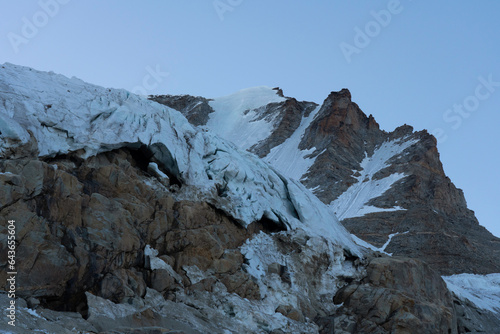 Gran Paradiso mountain peak and glacier view with crevasses detail and blue sky at blue hour. Mountaineering, normal route from chabod hut. global warming melting the ice
