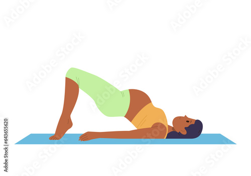 Healthy active pregnant woman in sportswear doing yoga standing in bridge pose on floor exercise mat