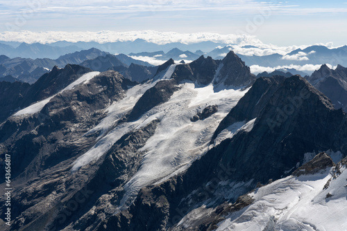 View from Gran Paradiso (National Park) mountain summit: glaciers of the massif and high rocky peaks. Mountains landscape. Global warming and climate change melting the glacier ice © Andrea