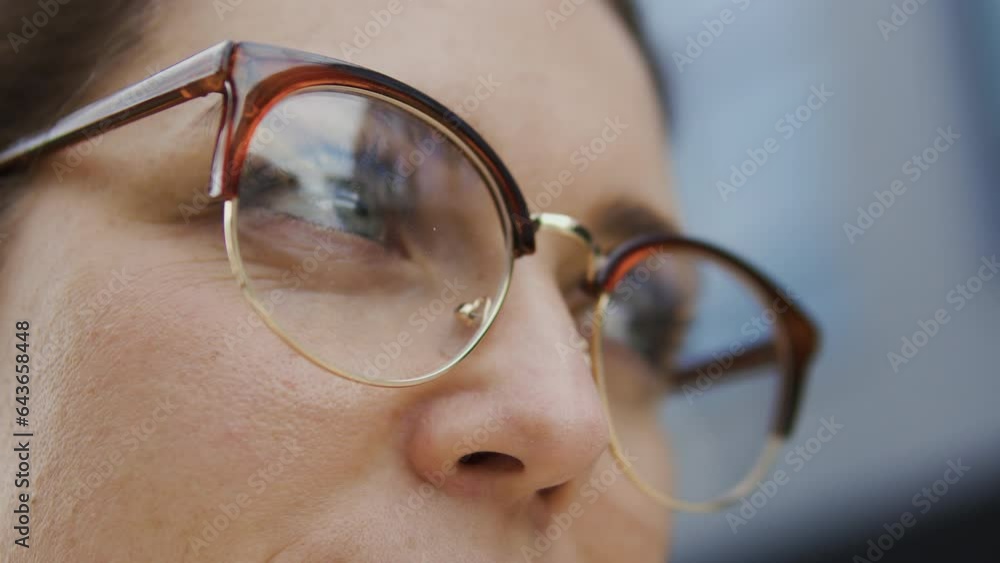 Macro close-up woman in eyeglasses standing outdoor and looking from side to side, vision problems like myopia and hyperopia and laser vision correction Macro close-up woman in eyeglasses standing outdoor and looking from side to side, vision problems like myopia and hyperopia and laser vision correction
