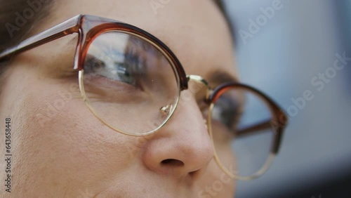 Macro close-up woman in eyeglasses standing outdoor and looking from side to side, vision problems like myopia and hyperopia and laser vision correction