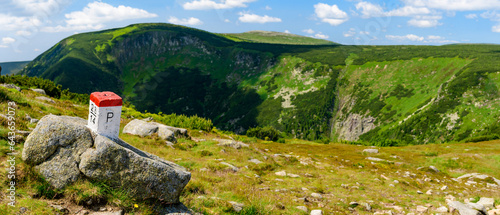 Giant Mountains, mountain panorama from the hiking trail to the top of Sniezka. View of the vast mountain slopes and trails on a sunny summer day. Polish-Czech border post.