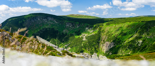 Fototapeta Naklejka Na Ścianę i Meble -  Giant Mountains, mountain panorama from the hiking trail to the top of Sniezka. View of the vast mountain slopes and trails on a sunny summer day.