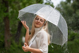 young woman under an umbrella in rainy weather